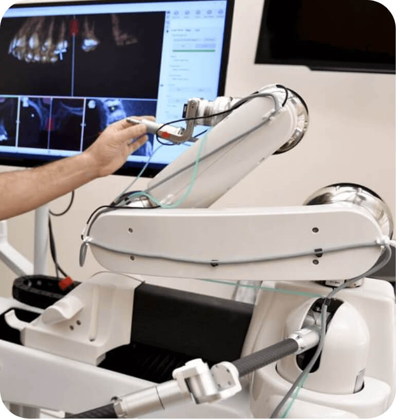 a dentist adjusting the Yomi dental robot's arm